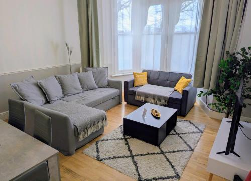a living room with a couch and a table at 2 Bedroom House with Garden and Free Parking -10 min to London Bridge and near Lewisham Hospital in Lewisham