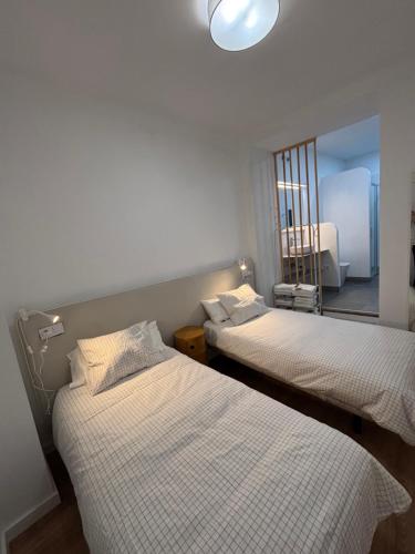 two beds in a room with a mirror at Cuatro Cantillos in Aguilar de la Frontera