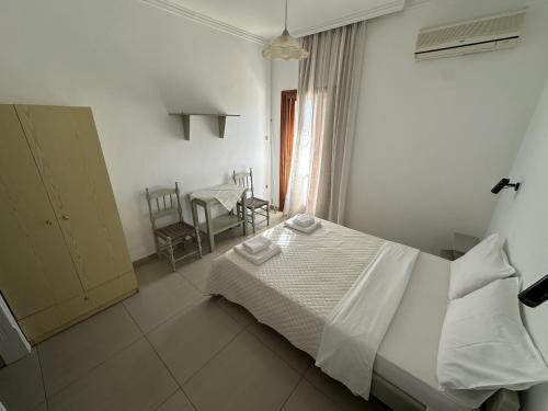 a bedroom with a bed and a table and chairs at Filoxenia Studios 1 in Palaiochora