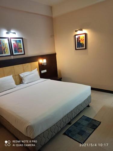 a bedroom with a large bed in a hotel room at Hotel Mirabel in Jajpur Road