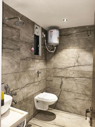 a bathroom with a toilet and a sink at Kings Executive and Restaurant in Tuljapur
