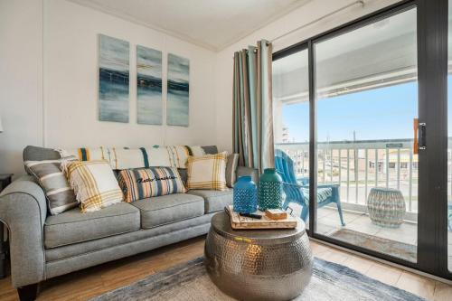 a living room with a couch and a balcony at Tipsea on the seawall in Galveston