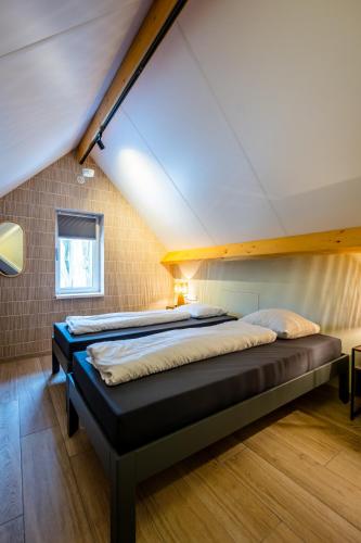 a bedroom with two beds in a attic at Vakantiepark Zevenbergen in Heesch