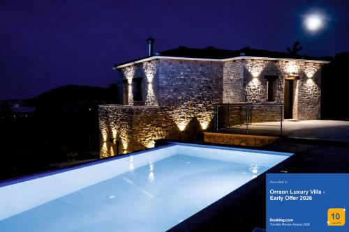 a villa with a swimming pool at night at Orraon Luxury Villa - Exclusive retreat with panoramic views and infinity pool in Lefkada