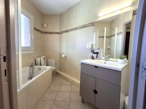 a bathroom with a tub and a sink and a bath tub at Studio avec piscine SAINT FLORENT - FLO300-259 in Saint-Florent
