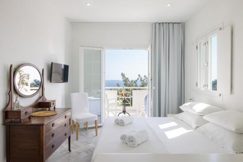 a bedroom with a bed and a dresser and a mirror at Villa Anthemoessa - Endless Seaview in Pythagoreio