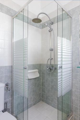 a bathroom with a shower with a glass door at Villa Anthemoessa - Endless Seaview in Pythagoreio