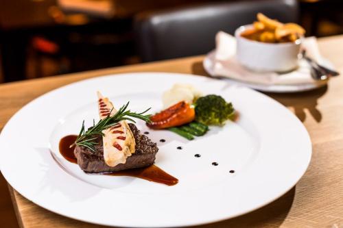 a white plate with food on a table at Trend Hotel in Banzkow