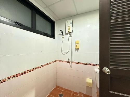 a bathroom with a toilet and a phone on the wall at Morakot Lanta Resort in Ko Lanta