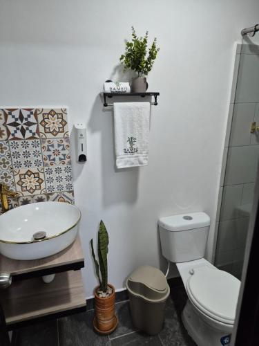 a bathroom with a toilet and a sink at Hotel Casa Bambu in Calima