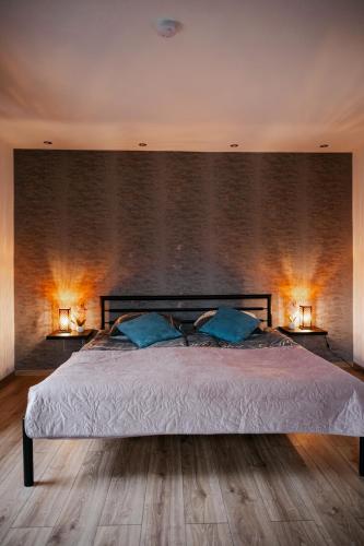 a bedroom with a large bed with two lamps at Apartament Damian in Kamienna Góra