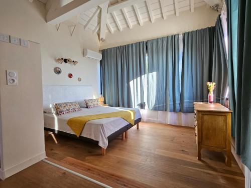 a bedroom with a bed and a large window at Mas de la tour de rey in Canet-en-Roussillon