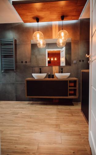 a bathroom with two sinks and two mirrors at Apartament Damian in Kamienna Góra