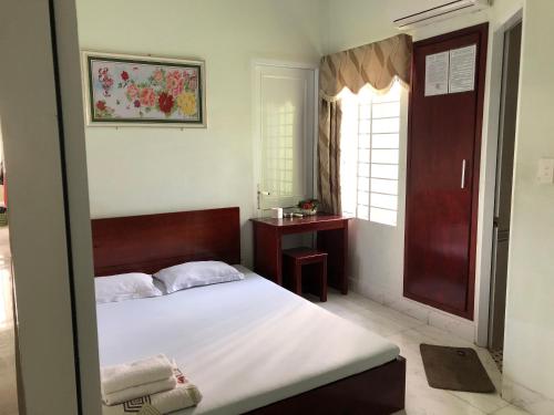 a bedroom with a large bed and a window at Gia Han Guesthouse in Vung Tau