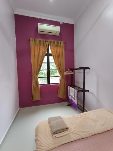 a bedroom with a bed and a window at NikNa Homestay Batu Rakit - WIFI Netflix in Kampong Ru Tujoh