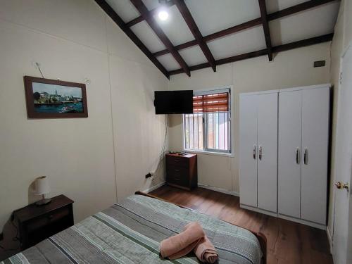 a bedroom with two beds and a television in it at Cabañas Arlenne in Valdivia