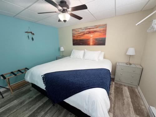 a bedroom with a bed and a ceiling fan at Drift Ashore House in Rocky Harbour