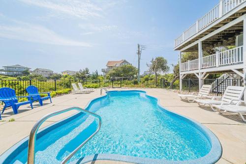 a swimming pool with lounge chairs and a swimming poolvisor at Arcadia - Duck, Caffey's Inlet, Ocean Views, 50 Yards to Beach, Pool, Pets OK, Cul-de-sac Location in Duck