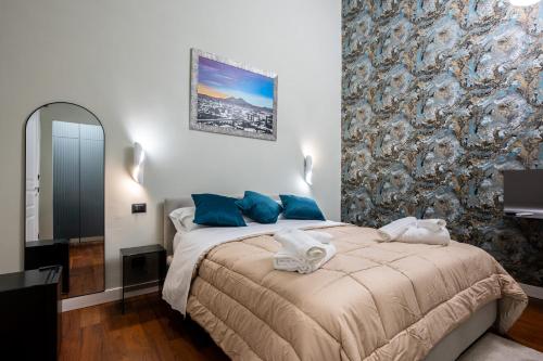 a bedroom with a large bed with blue pillows at ZapataRelais in Naples