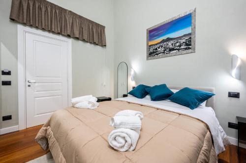 a bedroom with a large bed with blue pillows at ZapataRelais in Naples