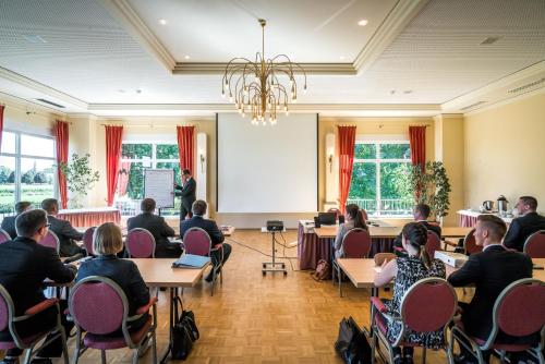 a group of people sitting at tables in a room at Trend Hotel in Banzkow