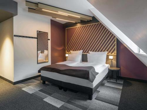 a bedroom with a bed and a staircase at B&B Hotel Leipzig-City in Leipzig