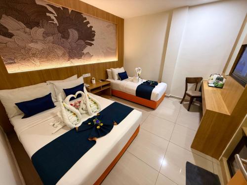a hotel room with two beds with towels on them at City Central Hotel in Kuala Lumpur
