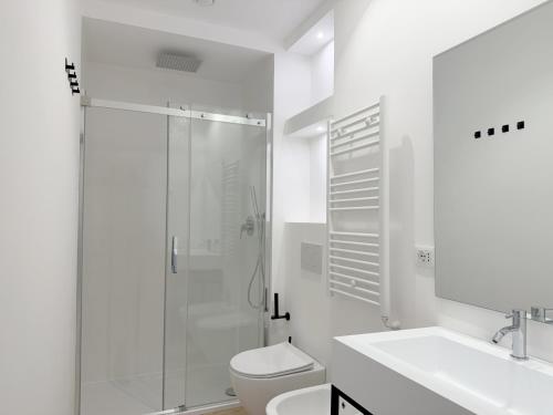 a white bathroom with a shower and a toilet at Palazzo Garbusi in Sarzana