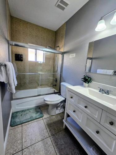 a bathroom with a toilet and a shower and a sink at Cozy Green Apartment in Homestead