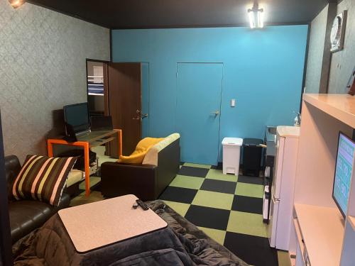 a living room with a couch and a desk with a computer at 民泊寿屋Kotobukiya Guesthouse in Muroran