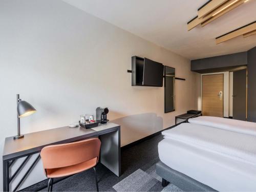 a hotel room with a bed and a desk at B&B HOTEL München-Schwabing in Munich