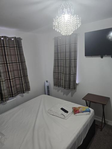 a bedroom with a bed and a chandelier at Kissingers lodge in Bridgend