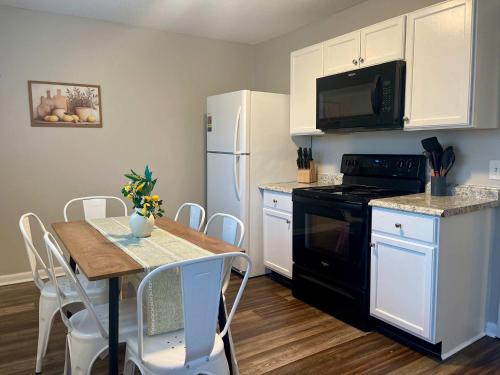 a kitchen with a table and a white refrigerator at Hillside Haven - affordable and convenient in Chattanooga