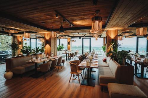 a restaurant with tables and chairs and windows at The Pines Bucegi Lodge in Bran