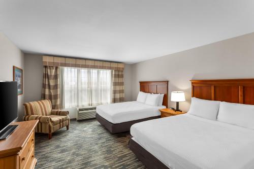 a hotel room with two beds and a television at Country Inn & Suites by Radisson, Beckley, WV in Beckley