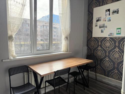 a table and chairs in a room with a window at Pulse capsule hotel in Almaty
