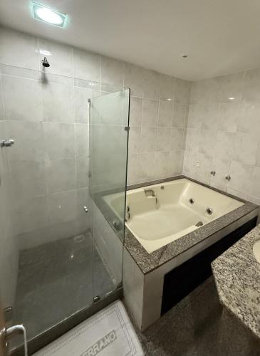 a bathroom with a bath tub and a shower at Hotel Serrano in Rio de Janeiro