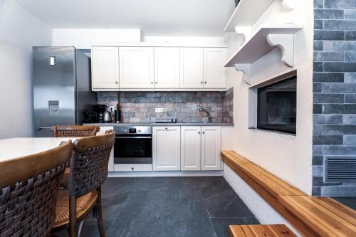 a kitchen with white cabinets and a table and chairs at Pelion Villa Serenity View in Pouríon