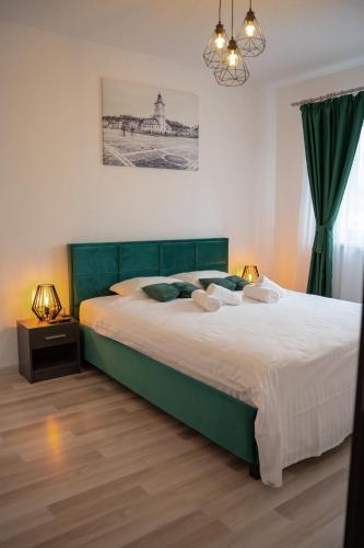 ein Schlafzimmer mit einem großen Bett mit grünem Kopfteil in der Unterkunft MrResidence in Sînpetru