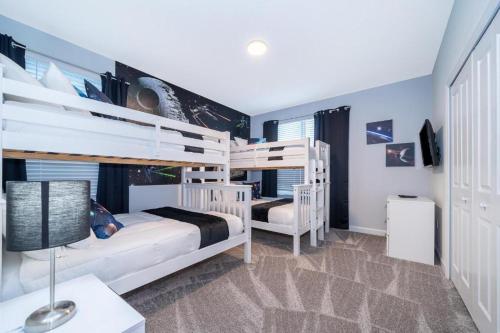 a bedroom with two bunk beds and a desk at Fabulous Villas 5 minutes away from Disney! in Kissimmee