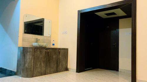 a bathroom with a sink and a television on a wall at Swarnpalace Hotel and Resort in Chaupāran