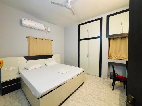 a bedroom with a white bed and a red chair at Swarnpalace Hotel and Resort in Chaupāran