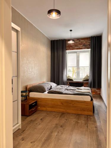 a bedroom with a bed and a window at Apart Brzeg in Brzeg