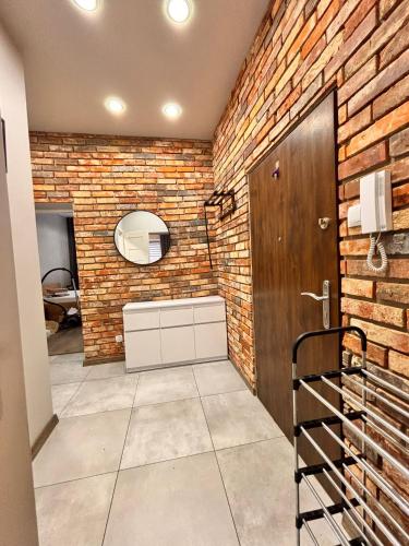 a bathroom with a brick wall and a wooden door at Apart Brzeg in Brzeg