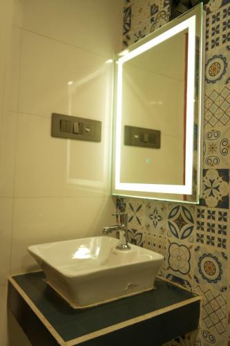 a bathroom with a sink and a mirror at Manish Inn Resort in Daulatābād