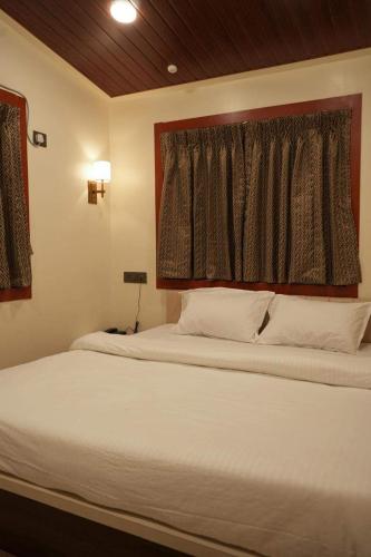 a bedroom with two beds and a window at Manish Inn Resort in Daulatābād