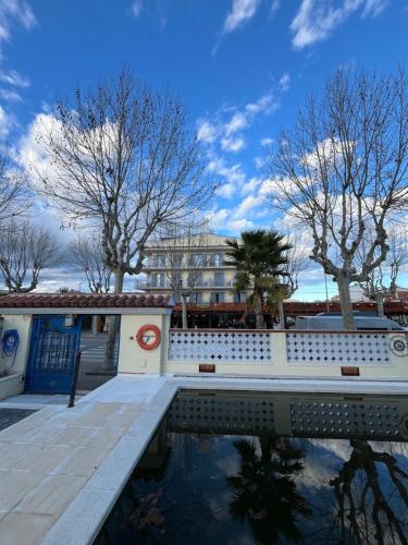 a reflection of a building in a body of water at Hotel Portofino in Empuriabrava