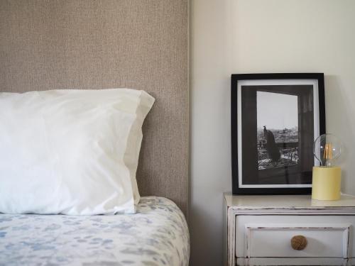 a bed with a pillow and a mirror on a nightstand at 12 Casa d'Avó in Albergaria-a-Velha