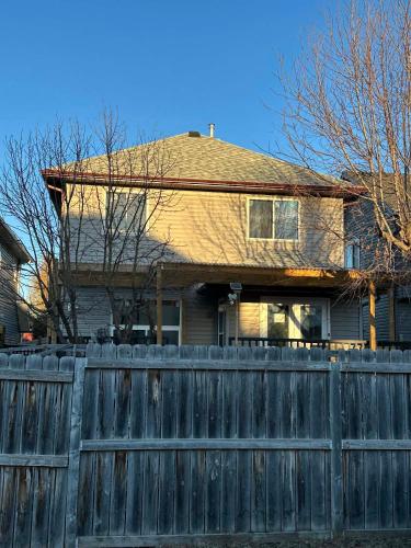 a house with a wooden fence in front of it at Jeli haus in Calgary