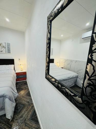 a mirror hanging on a wall in a bedroom at HAVELI Vinaros in Vinarós